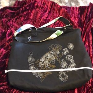 ON reversible tote with inside and outside pockets and snap closures .
